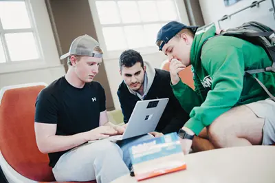 Three men looking at laptop